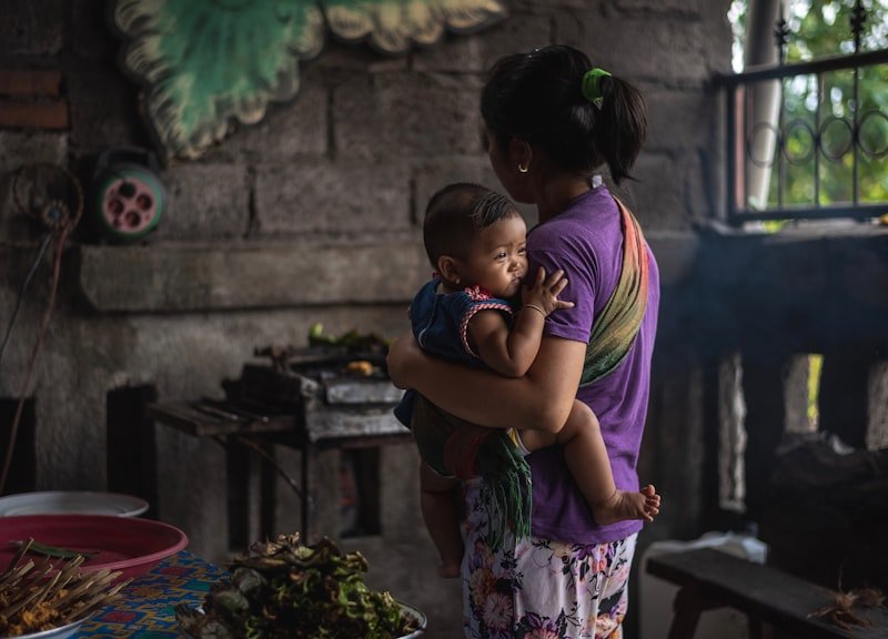A caregiver holding a young child at home