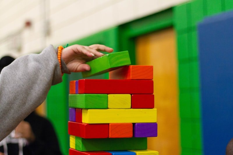 A child playing with wooden blocks on a living room floor